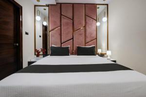 a bedroom with a large white bed with a wooden headboard at Astra Hotels & Suites - Koramangala in Bangalore