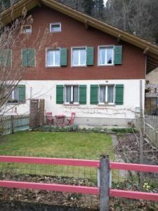 EmmeCottage - b48613 في Trubschachen: منزل احمر وبيضاء مع مصاريع خضراء