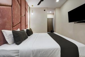 een slaapkamer met een groot bed en een flatscreen-tv bij Astra Hotels & Suites - Koramangala in Bangalore