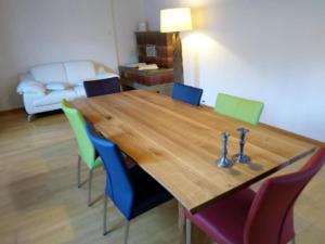 EmmeCottage - b48613 في Trubschachen: طاولة خشبية مع كراسي ملونة في غرفة المعيشة