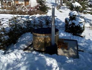 einen Whirlpool im Schnee im Hof in der Unterkunft Ferienhaus Luegisland - b48622 in Giswil