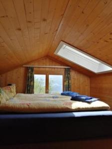 Schlafzimmer mit einem großen Bett und einem Fenster in der Unterkunft Ferienhaus Luegisland - b48622 in Giswil