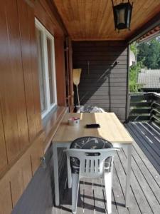 um alpendre com uma mesa e cadeiras num deque em Ferienhaus Luegisland - b48622 em Giswil