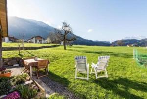 two chairs and a table in a yard at Bauernhof - Familienzimmer - b48580 in Lungern
