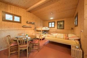 una camera con letto, tavolo e sedie di Bauernhof - Familienzimmer - b48580 a Lungern