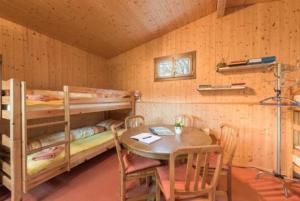 a room with two bunk beds and a table at Bauernhof - Familienzimmer - b48580 in Lungern