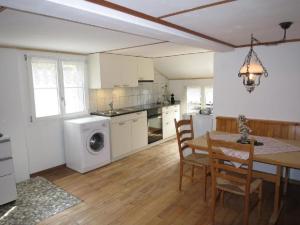 a kitchen and dining room with a table and a washing machine at Ferienwohnung Langberg - b48588 in Lauerz