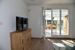 una sala de estar con TV en un tocador de madera en Haslers Hof - b48600, en Dinhard