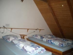 2 Betten in einem Dachzimmer mit Kissen in der Unterkunft "Hüttli" neben dem Bauernhof Fendrig - b48572 in Haslen