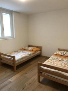 Cette chambre comprend 2 lits et une fenêtre. dans l'établissement Ferienwohnung Diala - b48608, à Lenz