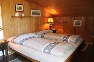 two beds in a room with wooden walls at Gemütliches Chalet zum Alleinbewohnen mit Top Garten & Bergblick, kostenloses WIFI, Ladestation für E-Autos in Grindelwald