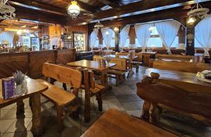 a restaurant with wooden tables and chairs and a bar at SCHRONISKO GOŚCINIEC RÓWNICA in Ustroń