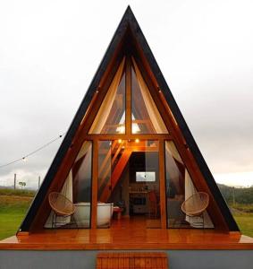 a triangle shaped house with a tub and windows at Cabana em Domingos Martins in Domingos Martins