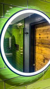 a round mirror on a green wall with a door at The Coach House - Your luxury private Brighton getaway with private parking in Brighton & Hove