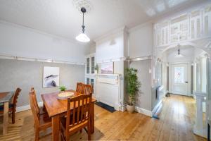 a dining room with a wooden table and chairs at MèRose Place - Cottage on George in Bathurst