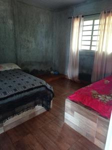 1 dormitorio con cama y ventana. en Fazendinha, en Itapuranga