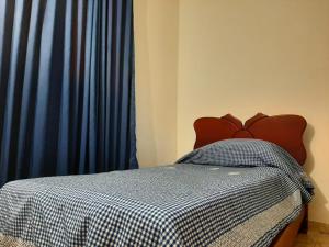 a bedroom with a bed with a blue curtain at Valle lanceros Melgar in Melgar