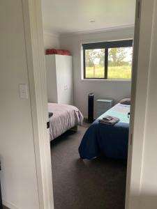 Un dormitorio con dos camas y una ventana. en Rural Guest Studio, en Kihikihi