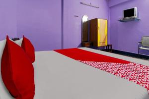 een slaapkamer met een groot bed met rode kussens bij OYO Sri Sivasakthi A/C Lodge in Sivakāsi