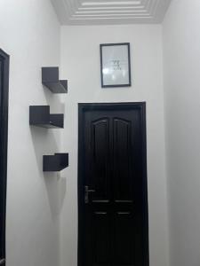 een kamer met een zwarte deur en een foto aan de muur bij Guest house in Cotonou