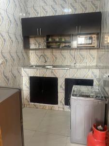 een keuken met een fornuis en een aanrecht bij Guest house in Cotonou