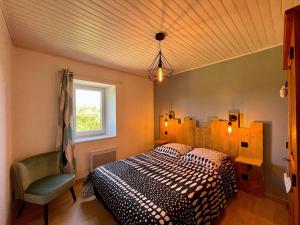 ein Schlafzimmer mit einem Bett und einem Stuhl in der Unterkunft Gîte Saint-Vert, 5 pièces, 7 personnes - FR-1-582-230 in Saint-Vert
