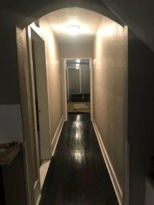 un corridoio vuoto con pavimento in legno scuro e un corridoio con una hallwayngthngth di Nice & Spacious House in Silsbee w/ Self Check-in a Silsbee
