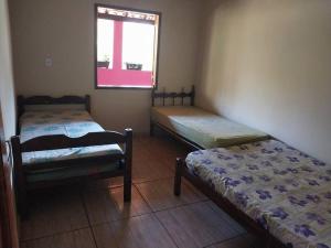 deux lits assis dans une pièce avec une fenêtre dans l'établissement Sítio do Vicente @sitiodovicenteop, à Ouro Preto