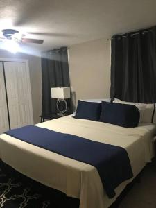 una camera da letto con un grande letto con cuscini blu di Nice & Spacious House in Silsbee w/ Self Check-in a Silsbee
