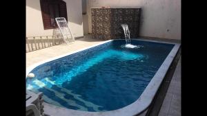 a swimming pool with a water fountain in a house at CASA PERUIBE in Peruíbe