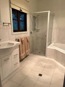 克萊爾的住宿－St Helen's Cottages，带淋浴、盥洗盆和浴缸的浴室