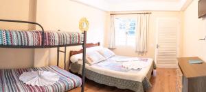 a bedroom with two bunk beds and a desk at Chalés Vill'Agi in Campos do Jordão