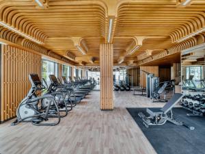 a gym with rows of exercise equipment and wooden ceilings at InterContinental Chiang Mai The Mae Ping, an IHG Hotel in Chiang Mai