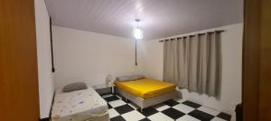 een kamer met 2 bedden in een kamer met een geruite vloer bij Breeze Floripa - Campeche in Florianópolis