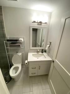 a white bathroom with a toilet and a sink at Luxury unit in the heart of Canmore in Canmore