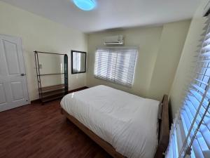 a bedroom with a white bed and a window at KT Villa 963 in Bangkok