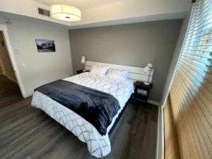 a bedroom with a white bed with a black blanket at Luxury unit in the heart of Canmore in Canmore