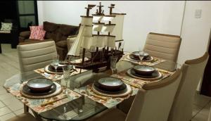 uma mesa de jantar com um barco em cima em Apartamento Completo Praia de Camboinha em Cabedelo