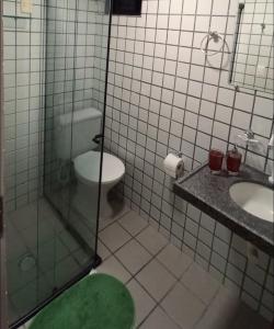 uma casa de banho com um WC, um lavatório e um chuveiro em Apartamento Completo Praia de Camboinha em Cabedelo