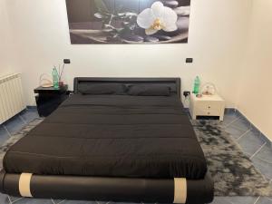 una camera da letto con un letto con copriletto nero di A Casa Di Gigi a Latina