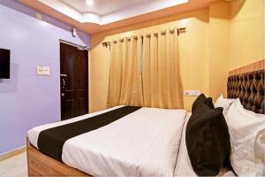 a bedroom with a bed and a window at Super Collection O Hotel Mahal in Kolkata
