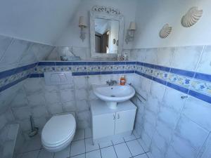 a bathroom with a white toilet and a sink at Landhaus Darss in Wieck +67 photos