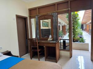a bedroom with a desk and a mirror at Hotel Priangan in Cirebon