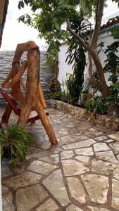 a wooden chair sitting on a stone patio at Pousada Simples Assim in Pirenópolis