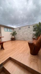 a room with a wooden floor and a brick wall at Pousada Simples Assim in Pirenópolis