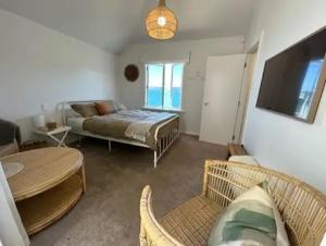 a living room with a bed and a couch at Seaglass Cottage in Lower Hutt