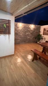 Zimmer mit einem Holztisch und einer Steinmauer in der Unterkunft Pousada Simples Assim in Pirenópolis