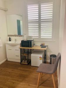 uma casa de banho com um lavatório e uma secretária com um micro-ondas em The Platypus Accommodation & Cafe em Cudal