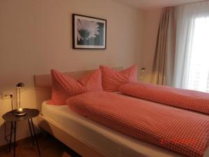 un letto con cuscini rossi sopra di Chalet Raufthubel, 1 Stock - b48651 a Mürren
