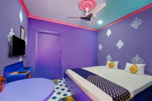 Dieses lila Zimmer verfügt über 2 Betten und einen TV. in der Unterkunft OYO Hotel Divyanka Lodge in Guwahati